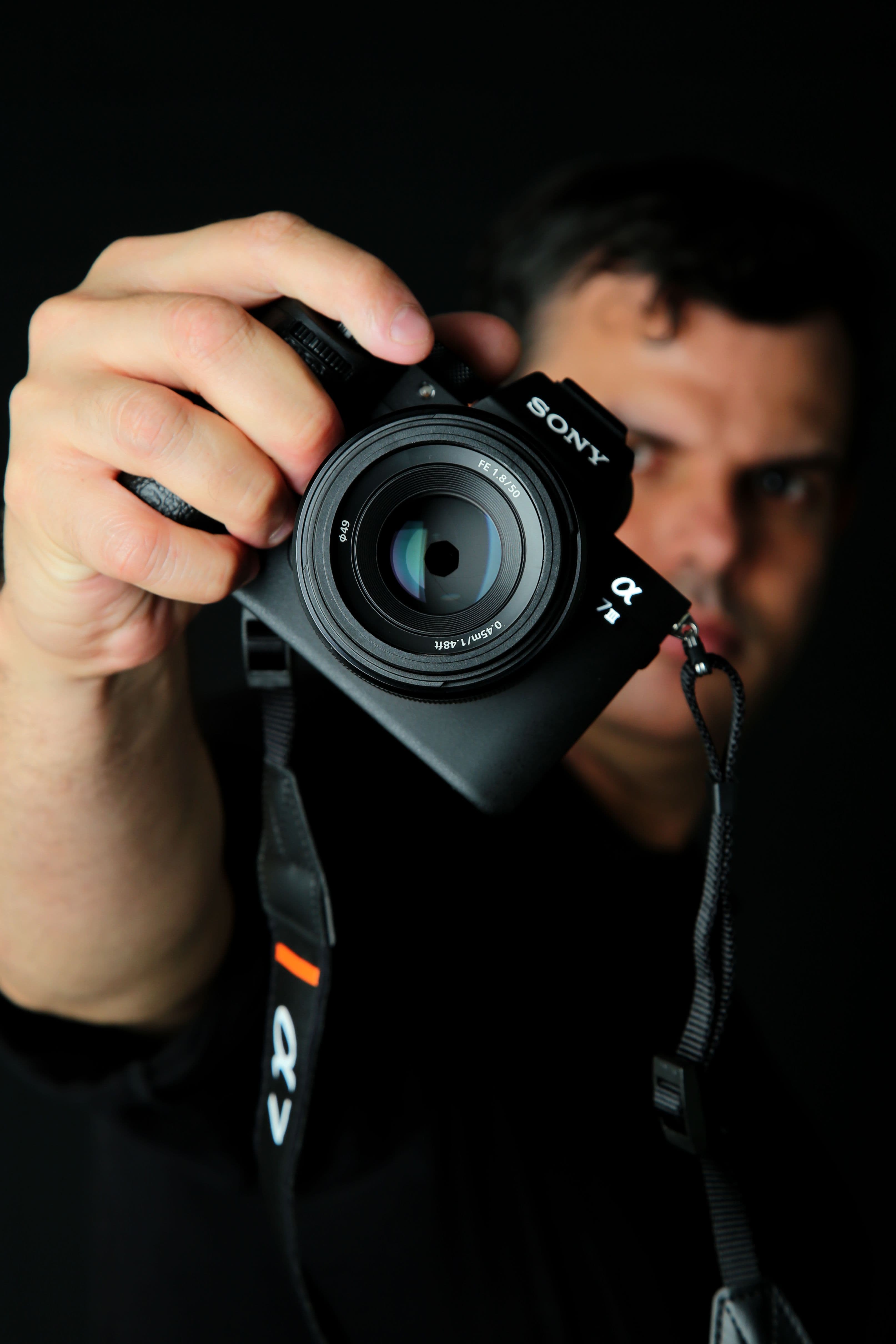 Ein professioneller Fotograf bei der Arbeit mit der Kamera, bereit für neue Kunden