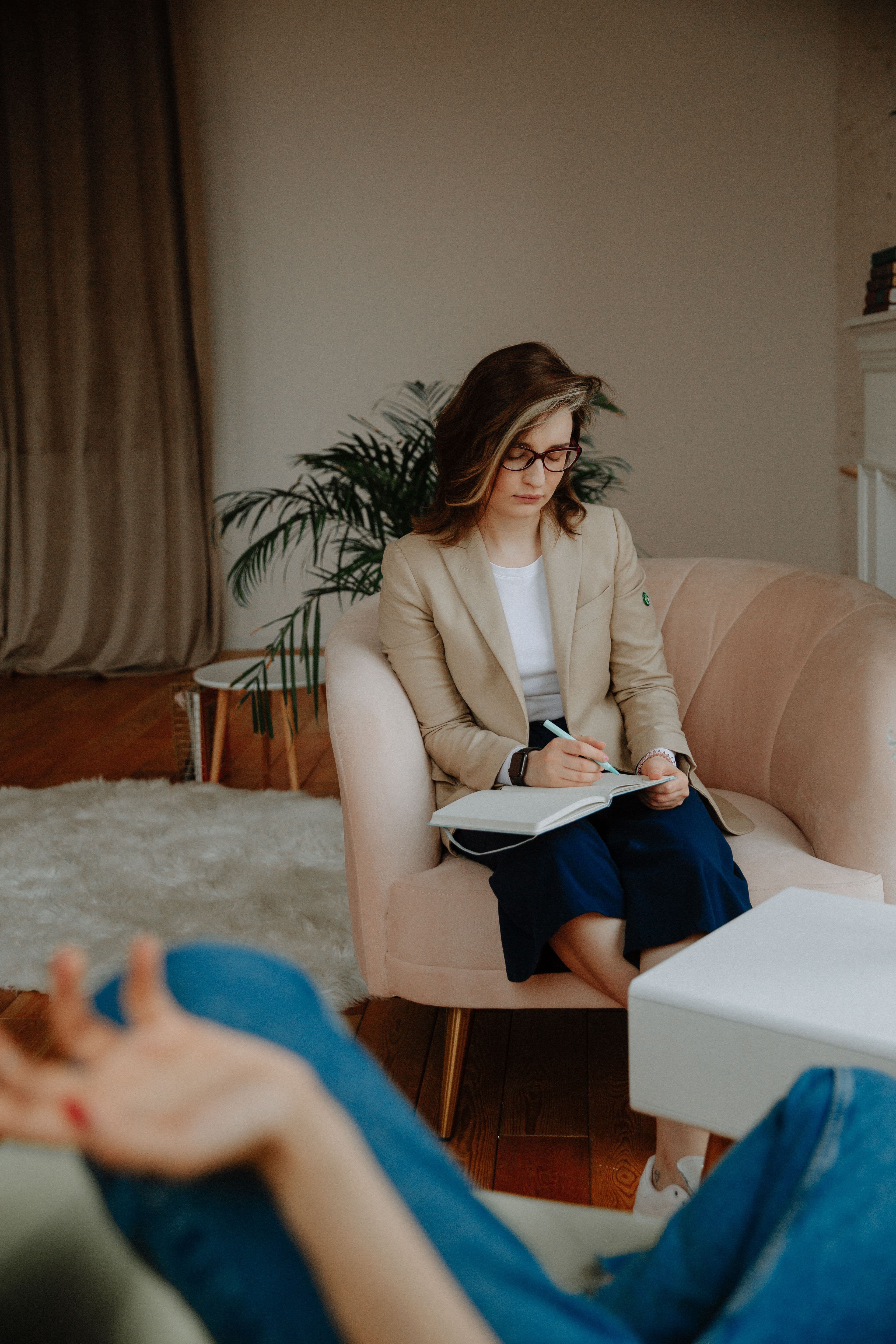 Une coach en séance, prenant des notes avec un client